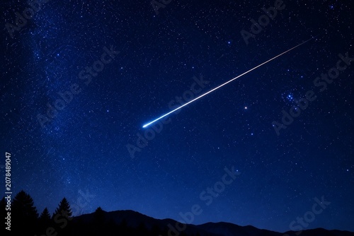 Meteor trail streaking across a clear night sky with star constellations.
