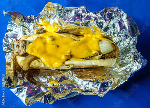 Bild auf Leinwand Sloppy Sausage sandwich with cheese sauce in a foil wrap