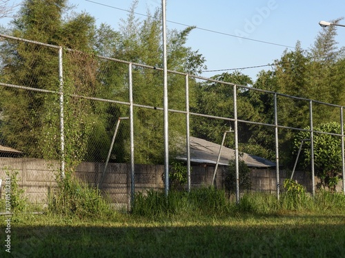 A high wire perimeter fencing installation protecting a rural residential property surrounded by wild tropical greenery.