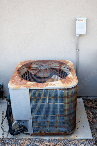 Φωτογραφία An old rusty outdoor central air conditioner condenser unit with a top ventilati