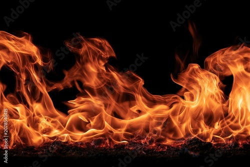 Intense fire flames rising from glowing embers against black background with sharp focus for cinematic movie and brand marketing