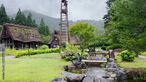 Traditional Japanese farmhouse with flowing spring water on rainy summer day