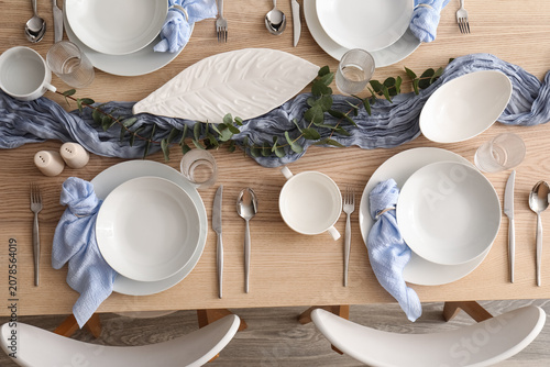 Принти на полотні Elegant dining table set with white dishes and blue napkins