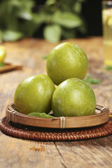 Fresh Green Plums in Wicker Basket on Rustic Wood Table - Organic Fruit Photography