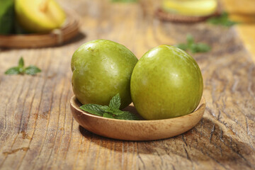 Fresh Green Chilean Dinosaur Egg Plums in Wooden Bowl Studio Food Photography