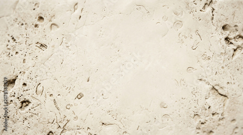 Travertine stone texture background, natural beige limestone surface with organic pits and fossils, rustic cream marble wall backdrop for architectural design