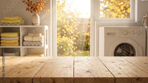 Empty wooden table top in bright laundry room interior with washing machine and towels for product mockup display.
