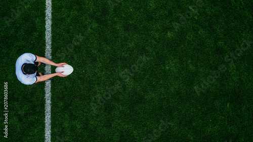 Top view of soccer player standing on football field with copy space for sports background