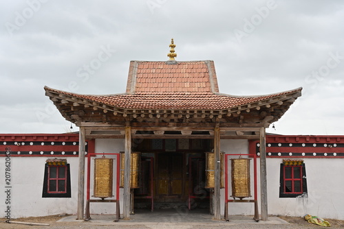 Quadro su tela A majestic Tibetan Buddhist temple stands adorned with golden roofs and prayer flags, its ancient walls whispering centuries of devotion against the Himalayan sky