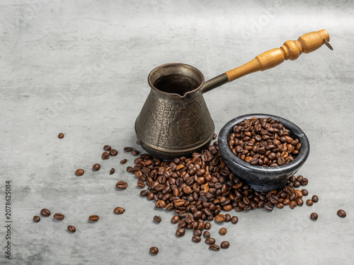 Cezve and a stone bowl with roasted coffee beans.