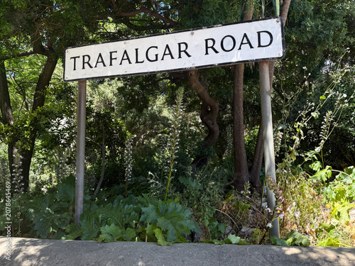 Foto Straßenschild der Trafalgar Road in Gibraltar vor Vegetation