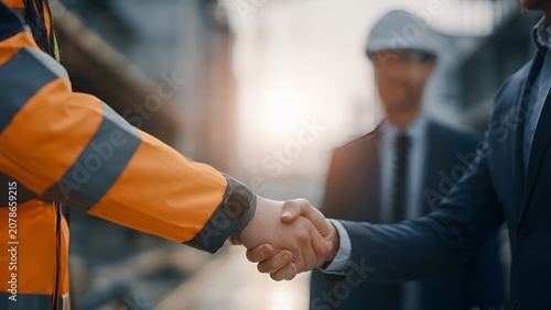 Business Executive Shaking Hands with Skilled Construction Worker Partnership Concept