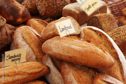 Photos Assortment of fresh baked artisanal bread with labels in a bakery shop close up