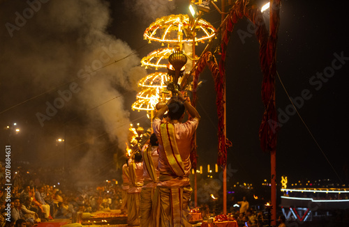 Ganga aarti, Portrait of young priest performing holy river ganges evening aarti at assi ghat in traditional dress with hindu rituals.