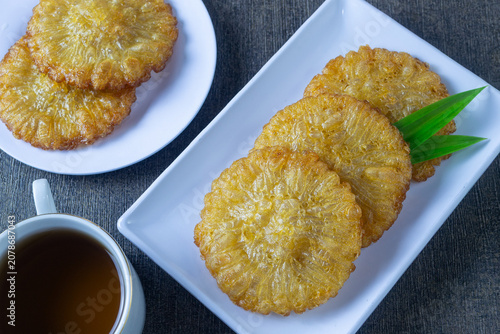 Photos Kue cucur gula merah served elegantly with aromatic pandan leaf on a ceramic pla