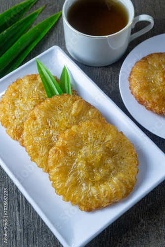 Konstfotografi Kue cucur gula merah served elegantly with aromatic pandan leaf on a ceramic pla