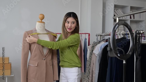 Fashion designer measuring blazer on mannequin for online business