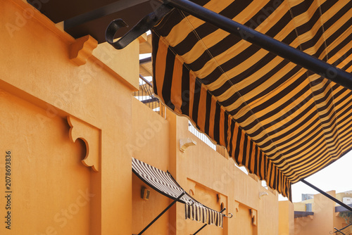 Striped awnings on warm yellow Middle Eastern style street
