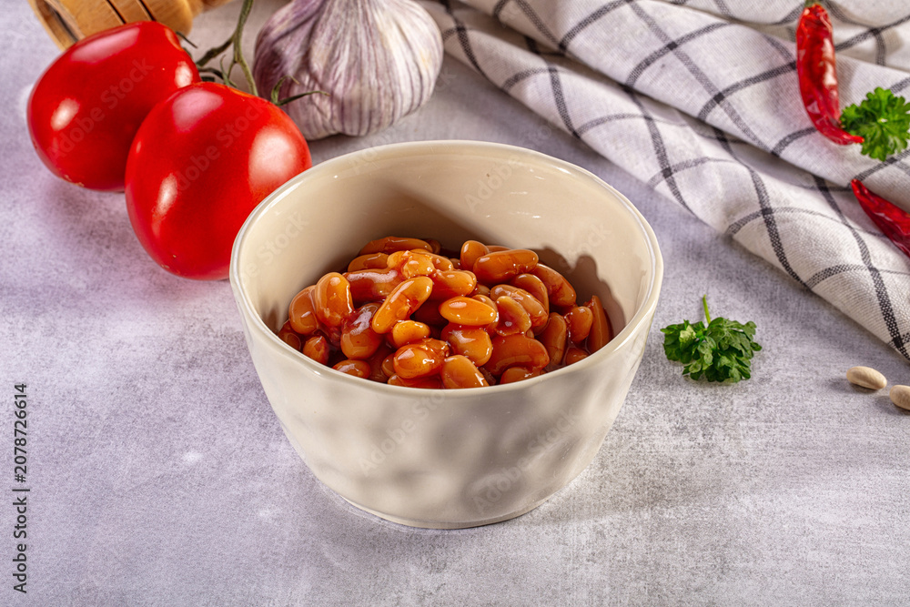 Fototapeta premium Baked beans in a ceramic bowl with fresh tomato, garlic, and chili ingredients