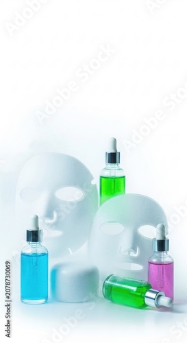Skincare products with sheet masks and colorful serums, White sheet masks stand beside colorful serum bottles on a clean background. Minimal composition with cosmetic containers. Realistic style. Skin