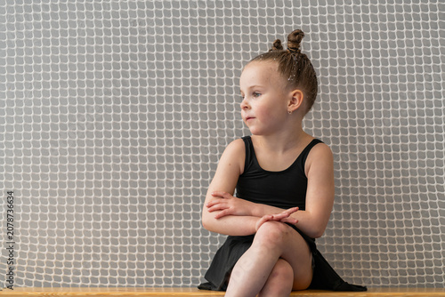 thoughtful little girl in a swimsuit patiently waits for training