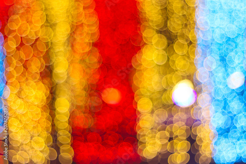 Warm yellow and red glowing bokeh background with vertical light streaks creating a cozy festive atmosphere
