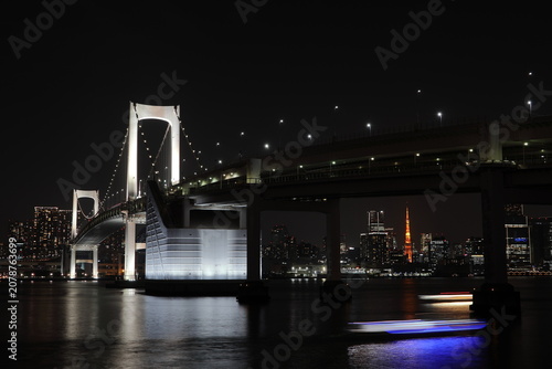 Tableau sur toile A houseboat passing under the Rainbow Bridge in Tokyo Bay at night, with Tokyo Tower visible in the distance
