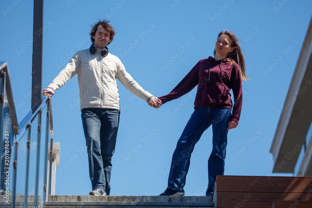 Obraz premium Couple walks hand in hand up outdoor stairs