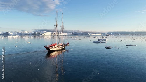 Tall ship sailing among icebergs in the arctic