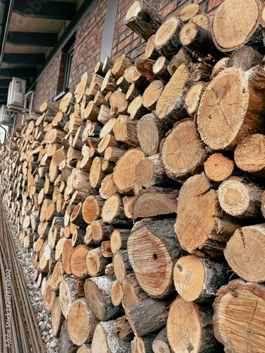 Stacked firewood logs prepared for heating season in autumn  