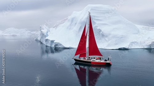 Yacht with red sails explores icy arctic waters