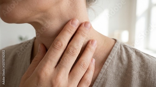 Close-up of a woman touching her neck and throat feeling pain and discomfort