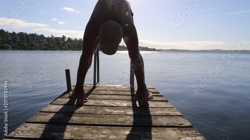 Stockholm, Sweden A man does callisthenics on a wooden pier in the morning on Lake Malaren. 