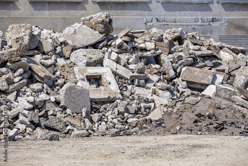 A large pile of concrete rubble and construction debris lies at a demolition site. This scene illustrates urban renewal processes and the environmental impact of building renovation projects.