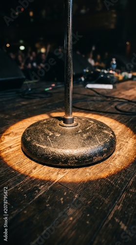 Obraz na płótnie Close-up of a vintage microphone on wooden base in dimly lit setting.