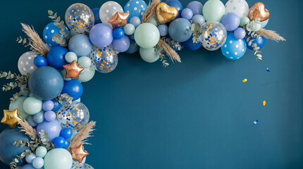 Elegant blue balloon garland with gold foil stars and hearts, pampas grass, and eucalyptus framing a dark navy background with spacious copyspace
