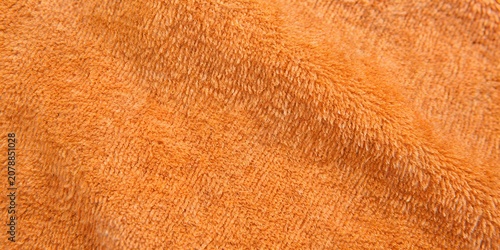 Foto Orange terry cloth towel texture background with soft wavy folds