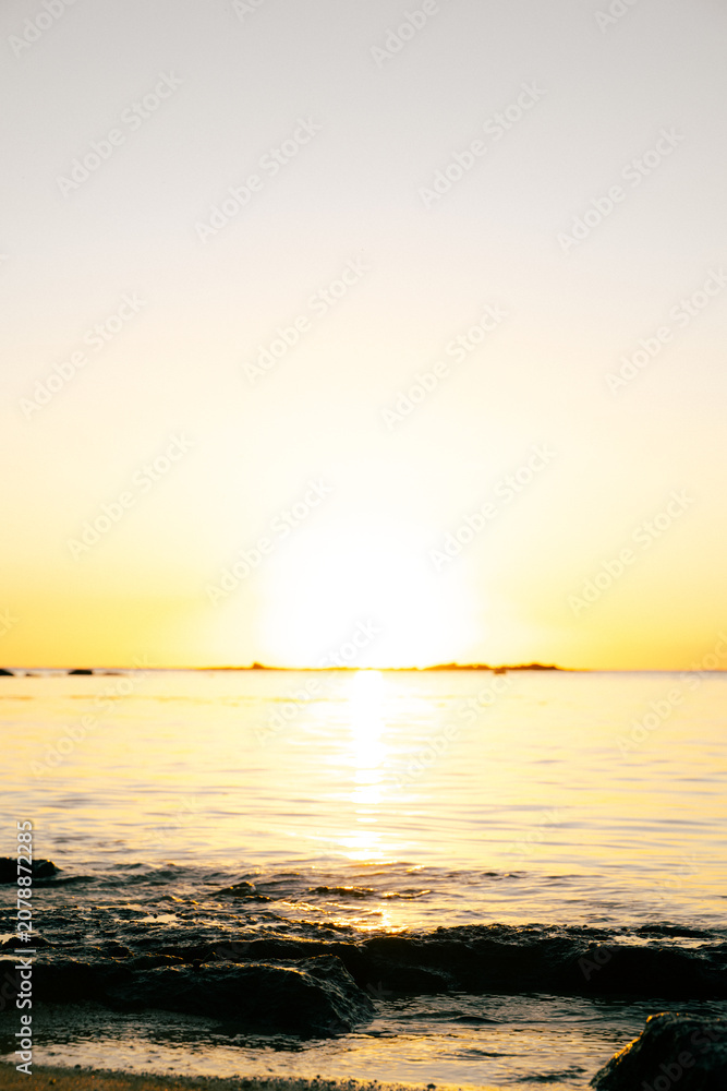 Obraz premium Calm tropical ocean reflecting golden sunset