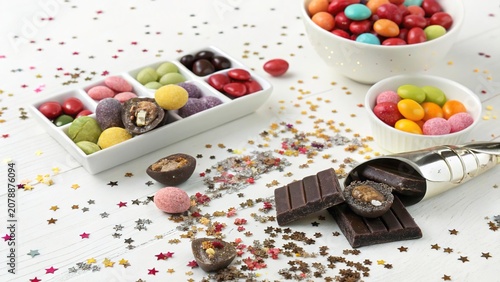 Colorful flat lay of assorted sweets with shiny confetti on a bright table