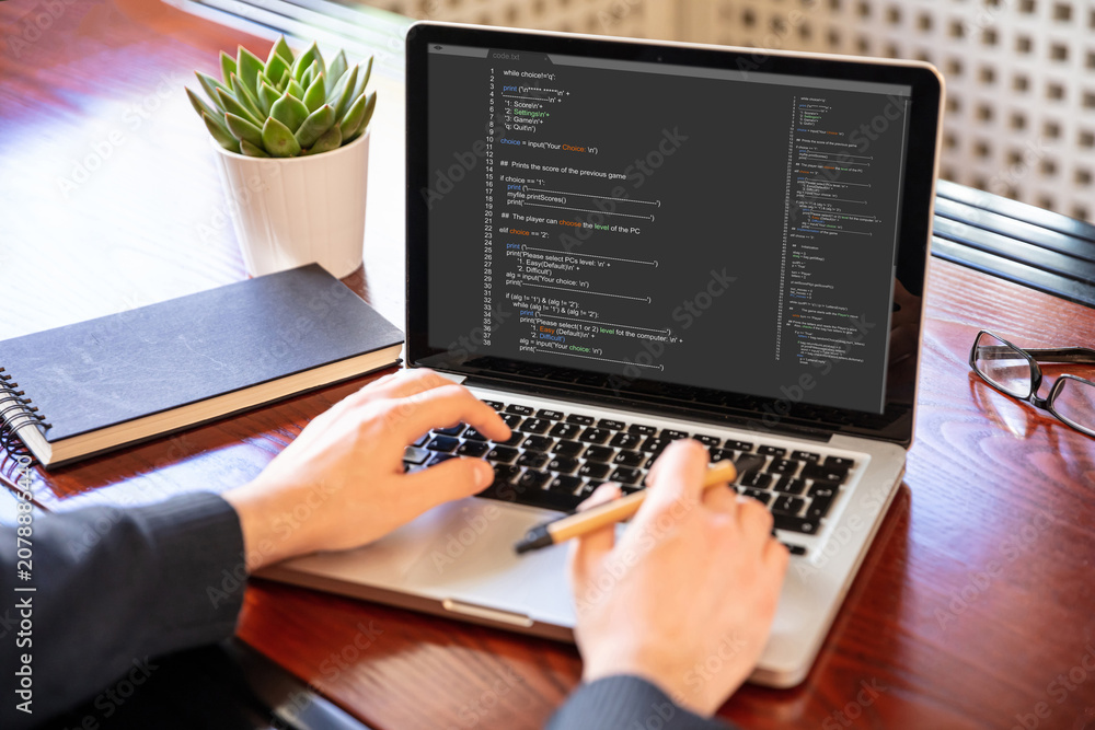 Fototapeta premium Man programming on a computer, office background
