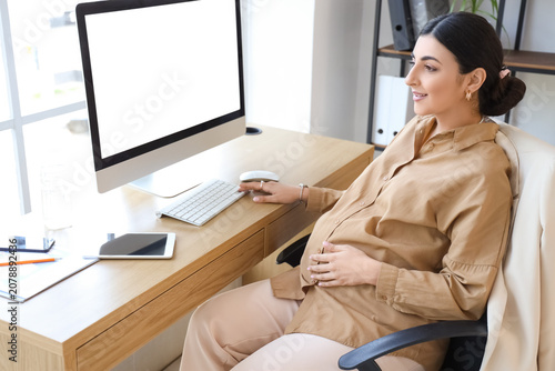 Pregnant businesswoman work...