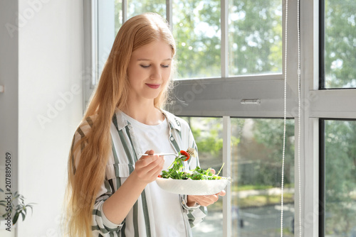 Young woman holding fork an...