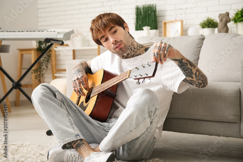Cool tattooed young man pla...