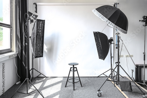 Tableau sur toile Small photo studio with a natural light from a window, white paper backdrop, lam