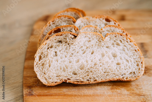 Freshly baked sourdough bread loaf with a crispy crust, partially sliced for eating