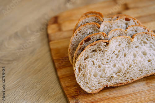 Freshly baked sourdough bread loaf with a crispy crust, partially sliced for eating