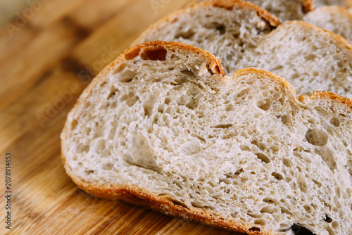 Freshly baked sourdough bread loaf with a crispy crust, partially sliced for eating