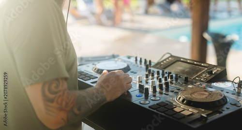 Dj mixing music at pool party during summer event - Entertainment and holidays concept -  Focus on hand