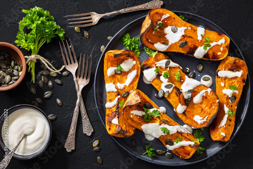 Baked butternut squash halves with yogurt sauce