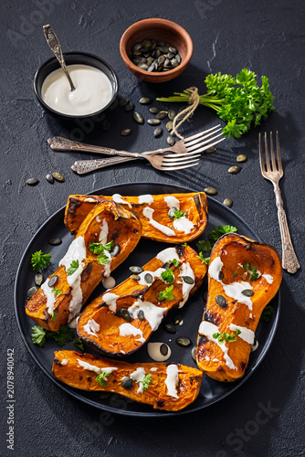 Baked butternut squash halves with yogurt sauce